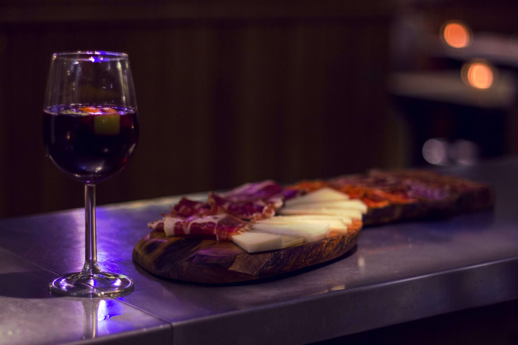 Plank met Spaanse ham en kaas en een glas rode wijn